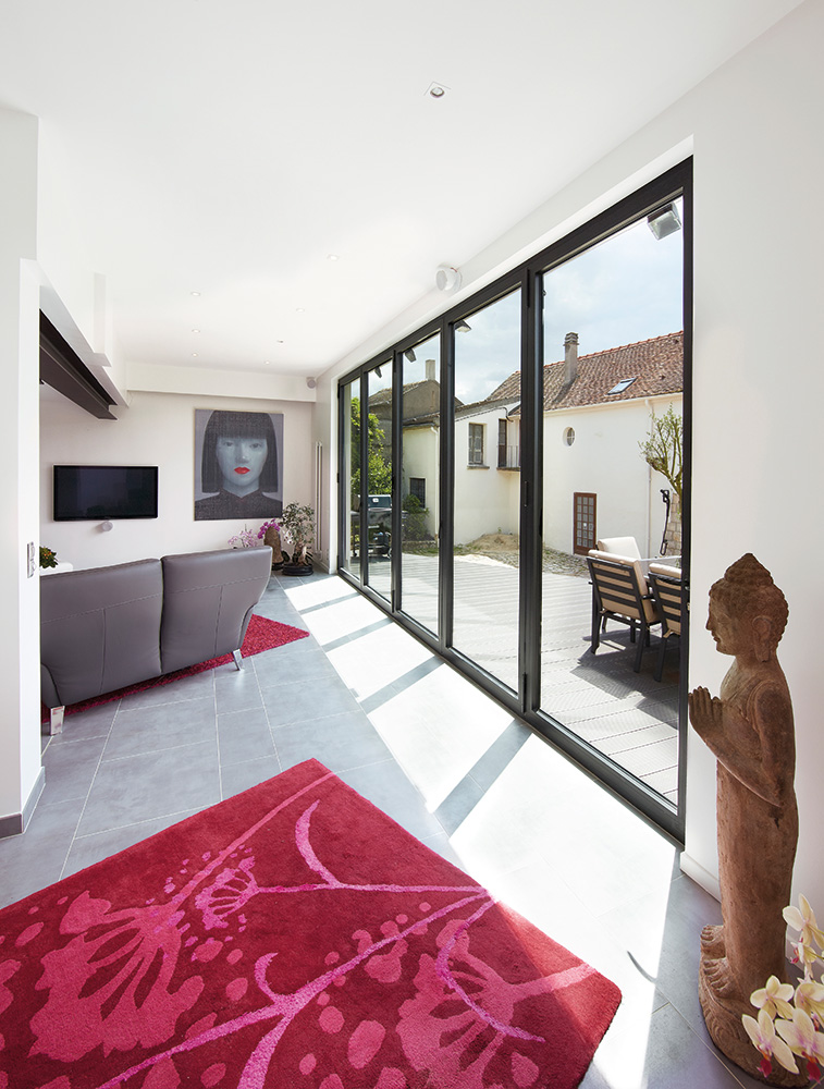 White lounge with pink rug and courtyard