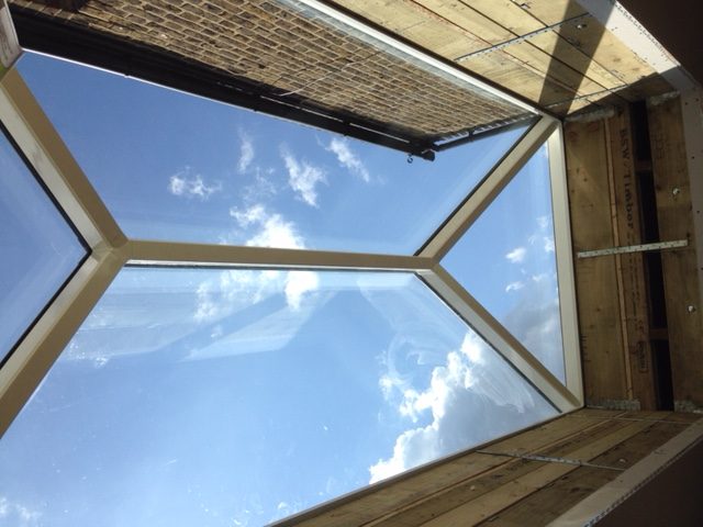 blue sky and white clouds seen through a rooflight