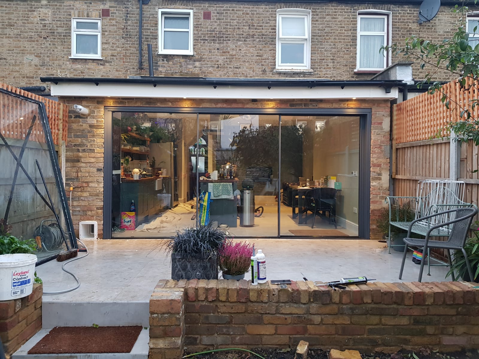 house extension with large patio doors plants and outdoor chairs