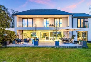 Large property with several windows, as well as Bifolding doors looking out onto patio and garden